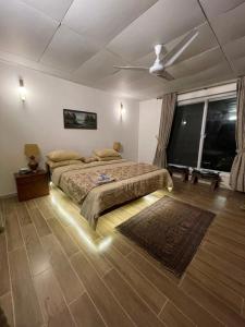 a bedroom with two beds and a ceiling fan at The Generals Inn in Bhurban