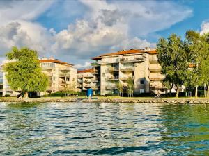 un edificio junto a una masa de agua en Balaton BeachSide Apartman Siófok N2, en Siófok