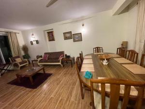 a living room with a wooden table and chairs at The Generals Inn in Bhurban