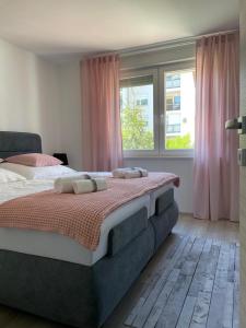 een slaapkamer met een groot bed en roze gordijnen bij Apartment Tomy in Rijeka
