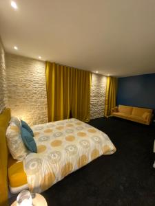 a bedroom with a large bed and a couch at L'ATELIER DU VIEUX BOIS Spa in Bayeux