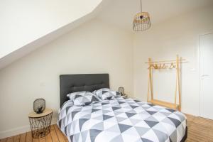 1 dormitorio con cama a cuadros en blanco y negro en La Parenthèse Honfleuraise bis, en Honfleur