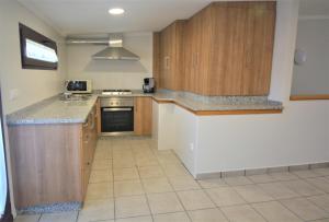 uma cozinha com armários de madeira e uma bancada em Apartamento con terraza en Cambados em Cambados