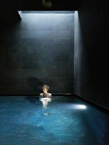 Eine Frau in einer Badewanne in einem dunklen Zimmer in der Unterkunft Bio Natur Refugium Blaslahof **** in Gsieser Tal