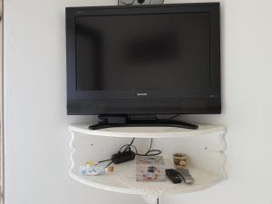 a television on a shelf with a remote control at Apartments Dora and Tonka Krk in Porat