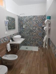 a bathroom with a toilet and a mosaic wall at HOTEL VILLA ISA in Pescara