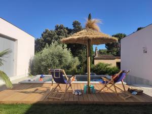 un patio con due sedie e un ombrellone e una piscina di Carré de Lune a Villeneuve-lès-Avignon