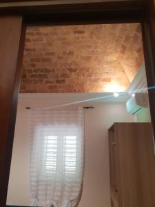 a room with a window and a brick wall at HOTEL VILLA ISA in Pescara