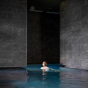 a person in a swimming pool in a dark room at Bio Natur Refugium Blaslahof **** in Valle Di Casies