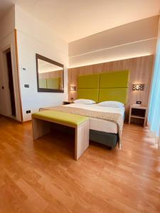 a bedroom with a large bed with a green headboard at Hotel St Gregory Park in Rimini