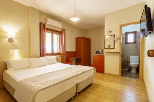 a bedroom with a bed and a bathroom with a toilet at Irini studios in Skiros