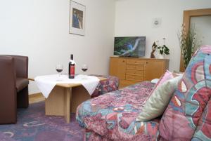 ein Wohnzimmer mit einem Sofa und einem Tisch mit Weingläsern in der Unterkunft Ferienwohnungen Gerti in Klopein am Klopeiner See