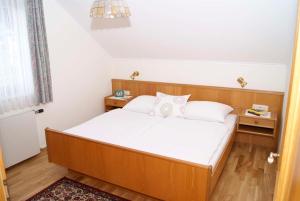 ein Schlafzimmer mit einem großen Bett mit weißer Bettwäsche und Kissen in der Unterkunft Ferienwohnungen Gerti in Klopein am Klopeiner See
