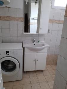 La salle de bains est pourvue d'un lave-linge et d'un lavabo. dans l'établissement Apartment with two bedrooms in City Centre in Drama Greece, à Dráma