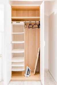 a closet with white shelves and a baseball bat at Lux Apartment in white in Gdańsk