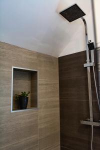 ein Bad mit einer Dusche und einer Glastür in der Unterkunft B&B De Kreek in Graauw