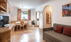 uma cozinha e sala de estar com uma mesa e um sofá em Residence Tombla em Ortisei