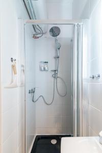 ein Bad mit einer Dusche und einem Waschbecken in der Unterkunft Lux Apartment in white in Danzig