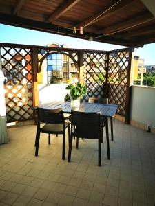 Une table et des chaises en bois sont disponibles sur la terrasse. dans l'établissement Appartamento mansardato Civitanova Marche, à Civitanova Marche