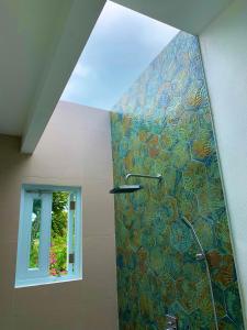 y baño con ducha y mosaico en la pared. en Villa del Carmen Boqueron en Cabo Rojo