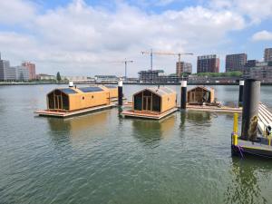 a group of houses in the water in a city at Wikkelboat Nr1 at Floating Rotterdam Rijnhaven in Rotterdam