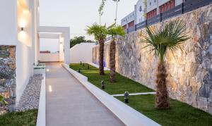 a hallway with palm trees next to a building at Epicentrum Suites in Limenaria