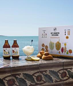 uma mesa com garrafas de cerveja e uma caixa de comida em Fronte Mare em Avola