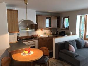 a kitchen and living room with a table and a couch at Ferienwohnung am Spenderberg in Vachendorf