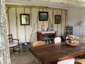 a dining room with a wooden table and chairs at Maison de vacances Gers in Manciet