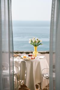a table with a vase of flowers on the beach at Hotel Piccolo Sant'Andrea in Praiano