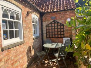 a patio with a table and chairs in a brick building at The Old Stable in Sleaford