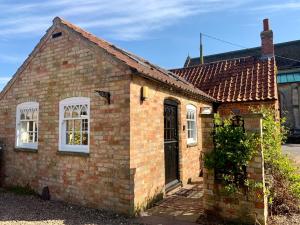 an old brick house with white windows and a door at The Old Stable in Sleaford