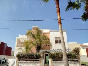 un edificio con palmeras delante en Villa à moins de 500m de la plage 3 Chambres et 4 SDB en Saïdia