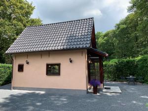 a small building with a window and a vase of flowers at Romantisch Gastenverblijf 'Het Vogelhuisje' in Lunteren