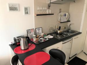 a small kitchen with a stove and a red counter top at Vip Home in Santiago