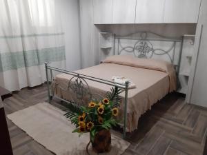 a bedroom with a bed and a vase with flowers at Villa Erilia in San Giovanni Suèrgiu +50 photos
