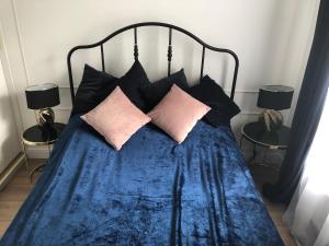 Mlociny Apartment في وارسو: سرير عليه بطانية ووسائد زرقاء