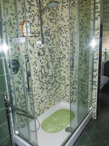 a shower with a glass enclosure in a bathroom at Green Quercia Apartment in Como