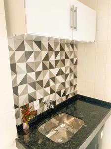 a kitchen with a sink and a tiled wall at Guarapari - Apto Linda Vista - Av Beira Mar-Praia do Morro in Guarapari +50 photos