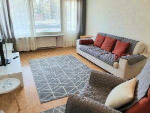 a living room with a couch and a rug at Comfortable Apartment MILA at a good location in Kotka