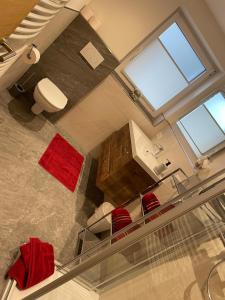 Una vista aérea de un baño con inodoro y sillas rojas. en Appartement Schneekristall, en Westendorf 31 fotos más