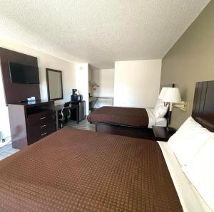 um quarto de hotel com duas camas e uma televisão de ecrã plano em Motel 6 Hermiston OR Umatilla em Hermiston