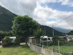 una casa con una recinzione e una montagna sullo sfondo di Résidence Gavarnie a Gèdre