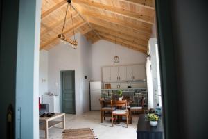 una cucina e una sala da pranzo con soffitti in legno di Rena's Panorama View House a Vóvikes