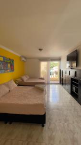 2 camas en una habitación con cocina y una habitación con 2 camas en Hotel Balcones de Bocagrande, en Cartagena de Indias