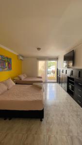 a large room with two beds and a kitchen at Hotel Balcones de Bocagrande in Cartagena de Indias