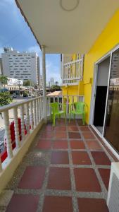 a balcony with two green chairs on a yellow building at Hotel Balcones de Bocagrande in Cartagena de Indias