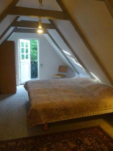 a bedroom with a large bed in the attic at Feriehus stråtækt bindingsværksidyl in Maribo