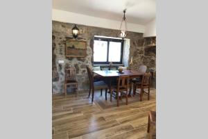 a dining room with stone walls and a table and chairs at Grandfather's House in Tábua