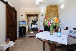 Casa Vasilia Traditional Home في Kástellos: غرفة معيشة مع طاولة عليها زهور
